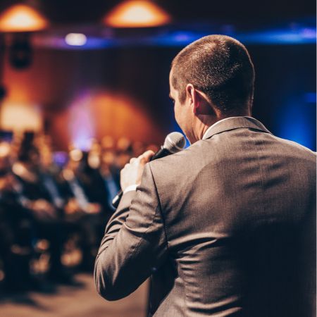 Speaker-in-a-suit-with-an-audience